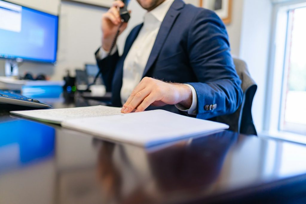 Person writing on paper at an office desk